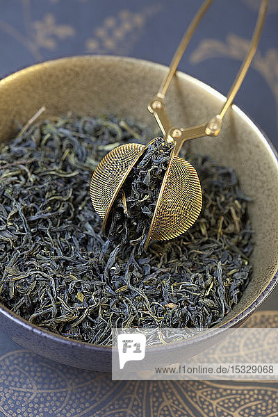 Mao Feng  grüner Tee aus China mit einem Teesieb in einer Schale