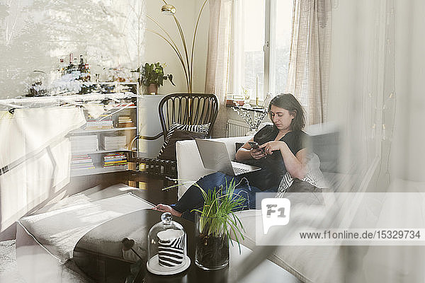 Young woman using laptop on sofa