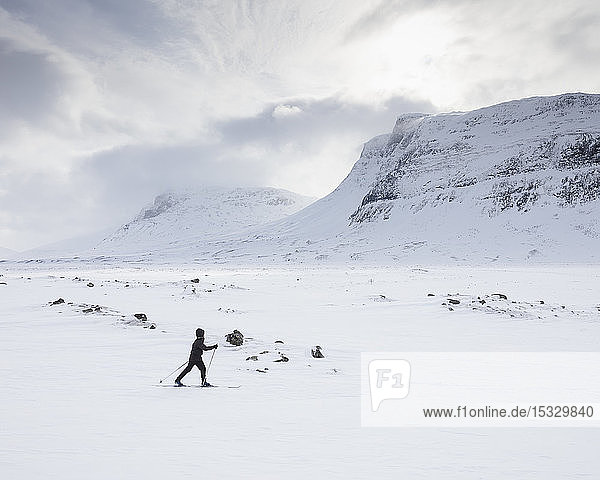 Frau beim Skifahren in den Bergen auf der Kungsleden-Piste in Lappland  Schweden