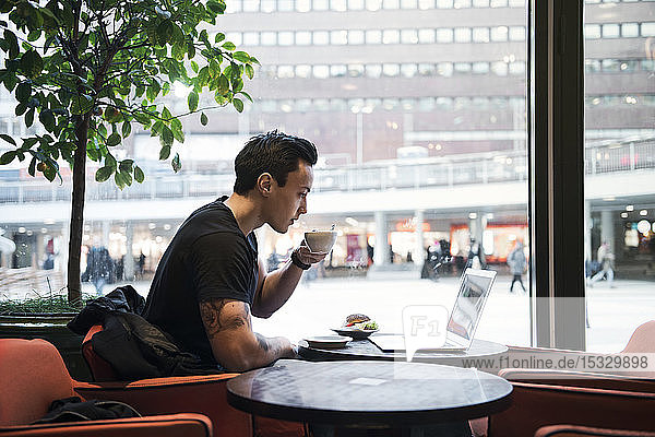 Man using laptop in cafe