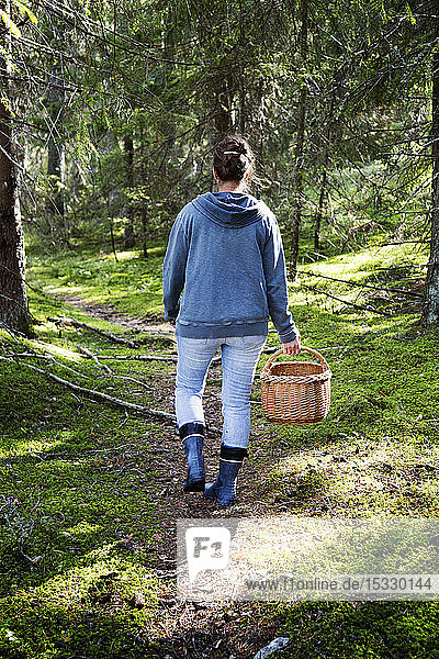 Woman picking mushrooms in forest