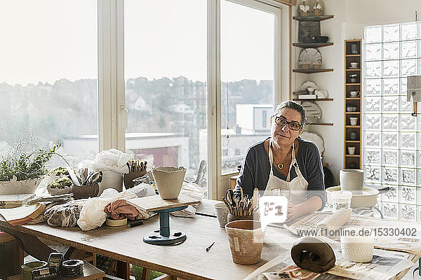 Woman at desk in pottery workshop