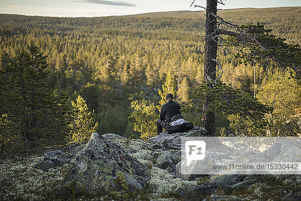 Man sitting on rock in Tofsingdalen Nature Reserve in Sweden