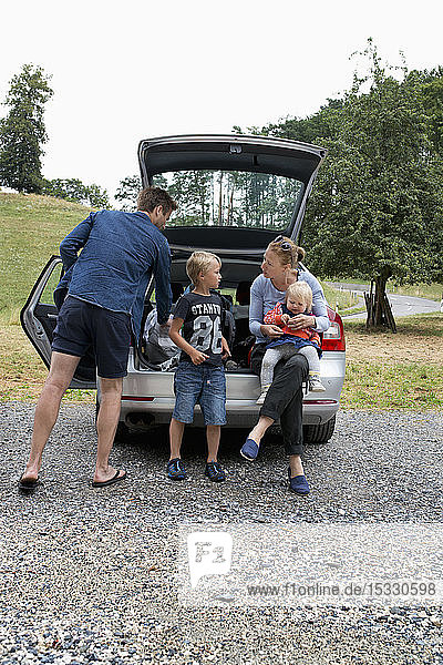 Family standing next to car
