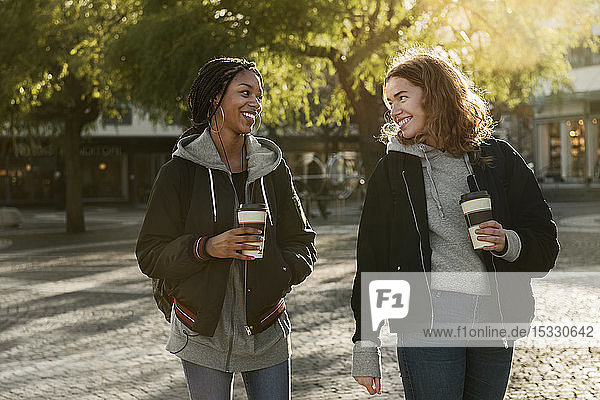 Smiling teenage girls with coffee cups