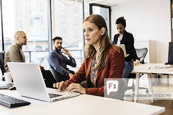 Businesswoman using laptop at desk