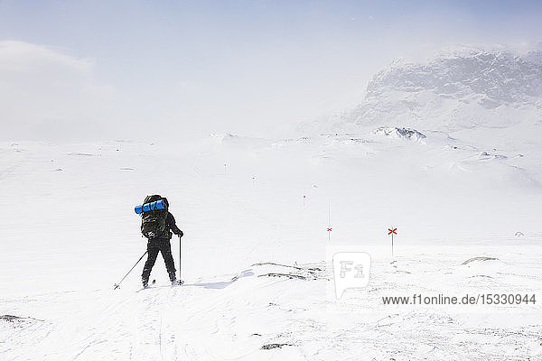 Woman skiing by mountains on Kungsleden train in Lapland Sweden