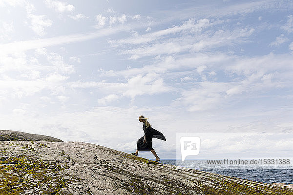 Woman wearing black walking on rock