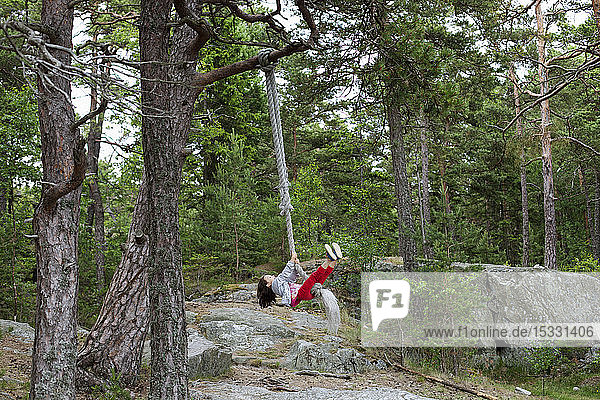 Girl swinging on rope swing