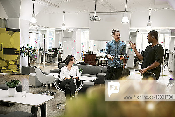 Coworkers talking in office