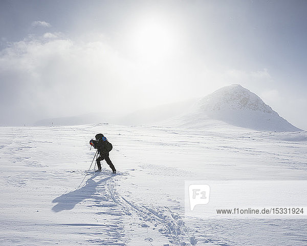 Frau beim Skifahren in den Bergen auf dem Kungsleden in Lappland,  Schweden