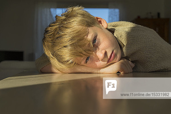 Boy leaning on table
