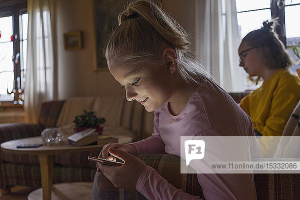 Teenage girl looking at cellphone indoors