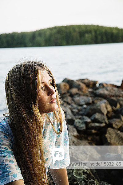 Portrait of young woman with lake in background