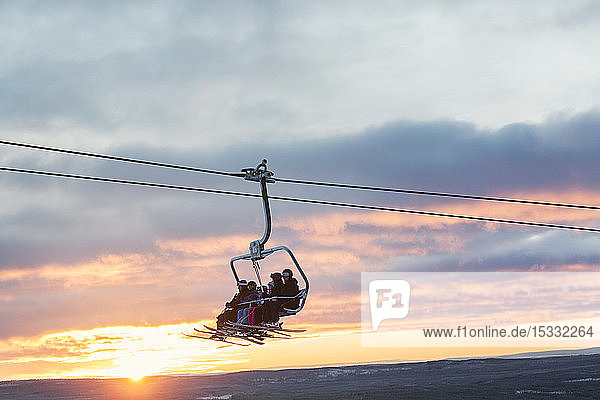 Silhouette of people on ski lift