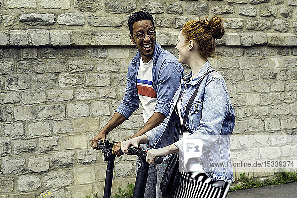 Couple riding push scooters