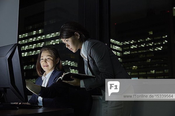 Japanische Geschäftsleute  die bis spät in die Nacht arbeiten