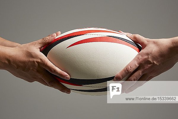 Hände halten Rugbyball