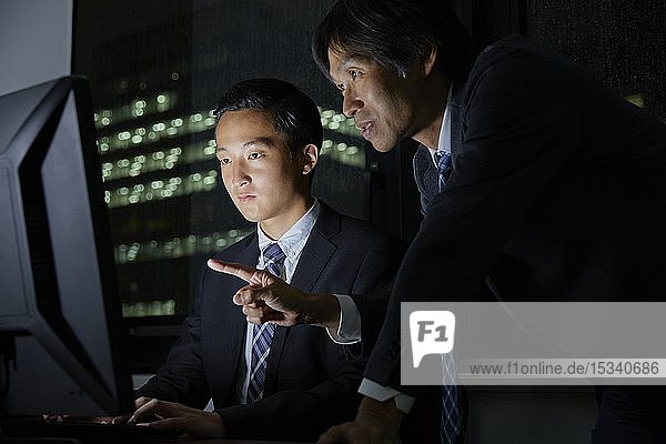 Japanische Geschäftsleute  die bis spät in die Nacht arbeiten