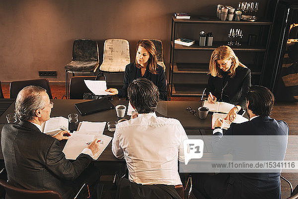 High angle view of financial advisors brainstorming in board room at office