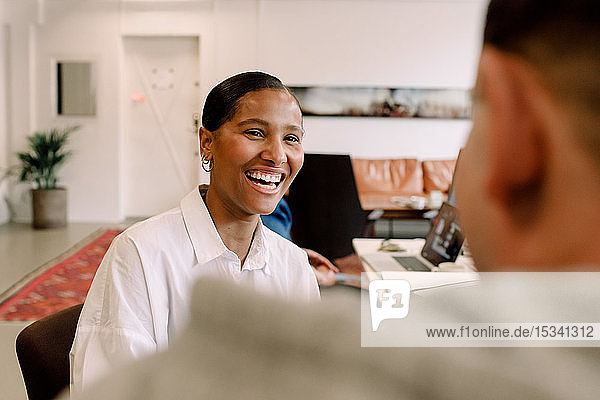 Smiling businesswoman looking at her colleague in office
