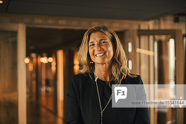Porträt einer reifen  berufstätigen Frau  die in einer Anwaltskanzlei lächelt