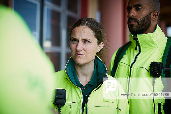 Female paramedic standing with coworker outside hospital