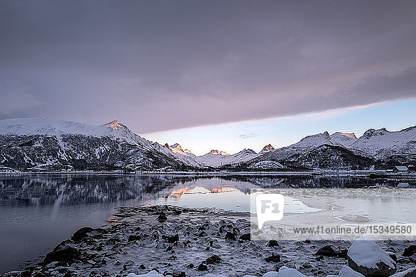 Beautiful calm fjord reflections at sunset in a wintry Lofoten Islands Nordland Arctic Norway Europe