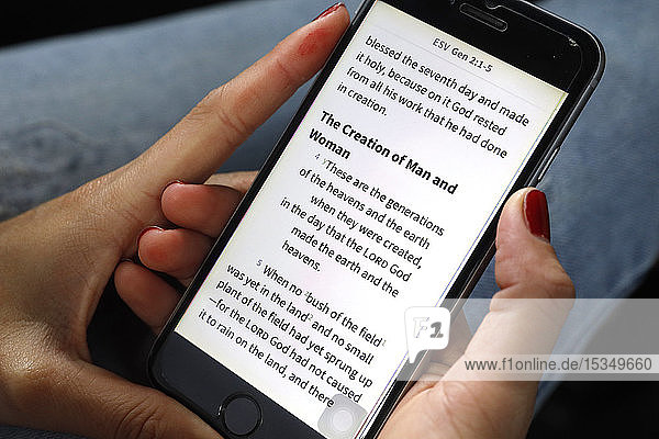 Christin liest eine digitale Bibel auf Englisch auf einem Smartphone  Vietnam  Indochina  Südostasien  Asien
