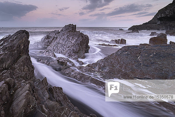 Wellen schlagen um die zerklüfteten Felsen am Wildersmouth Beach  Ilfracombe  Devon  England  Vereinigtes Königreich  Europa