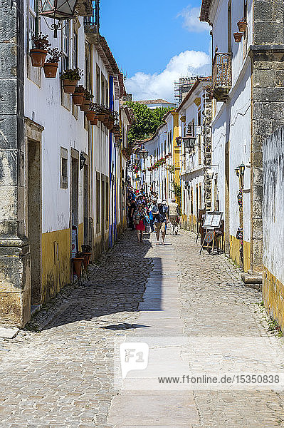Typical narrow street with shops and tourists in the fortified city of Obidos  Leiria District  Estremadura  Portugal  Europe