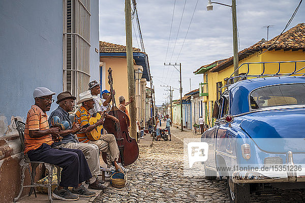 Ältere Kubaner musizieren auf der Straße  amerikanischer Oldtimer  Trinidad  Provinz Sancti Spiritus  Kuba  Westindien  Karibik  Mittelamerika