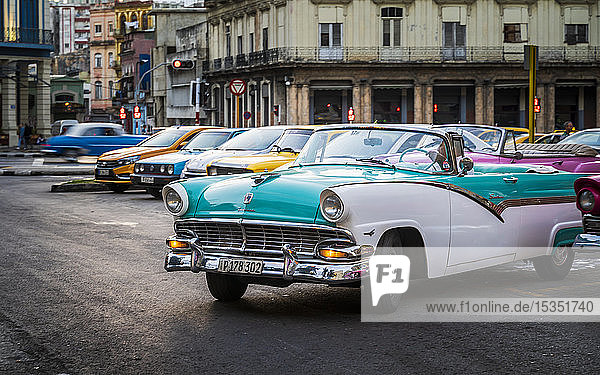Bunte alte amerikanische Taxis in Havanna in der Abenddämmerung  UNESCO-Weltkulturerbe  La Habana  Kuba  Westindien  Karibik  Mittelamerika