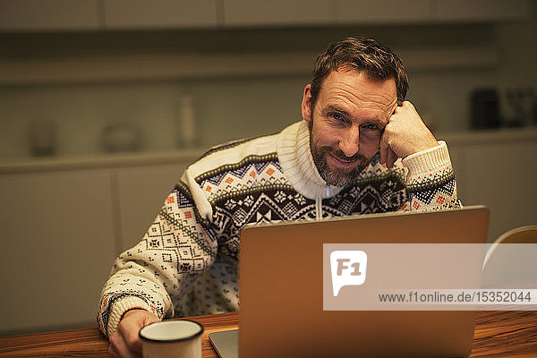 Casual businessman using laptop on table at home