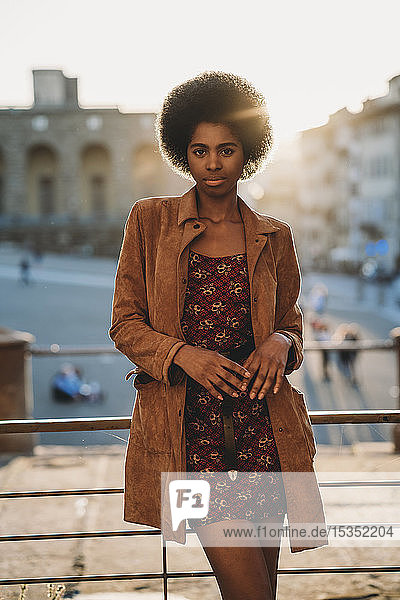 Junge Frau mit afrofarbenen Haaren  die am Geländer lehnt  Florenz  Toskana  Italien