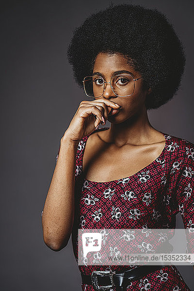 Young woman with afro hair against grey background