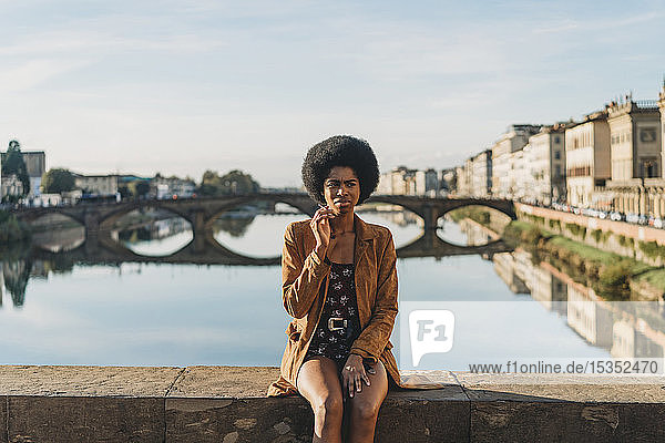 Young woman with afro hair smoking on bridge  Florence  Toscana  Italy