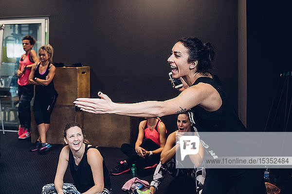 Group of women training in gym  laughing while taking a break
