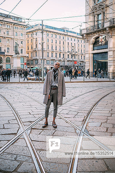 Stilvoller Mann posiert auf Straßenbahnschienen auf der Piazza  Mailand  Italien