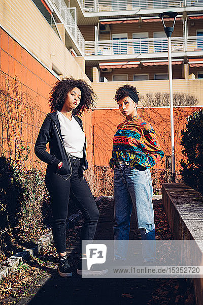 Two cool young female friends in urban garden  portrait