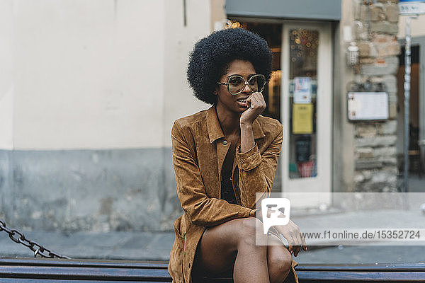 Young woman with afro hair waiting in front of shop