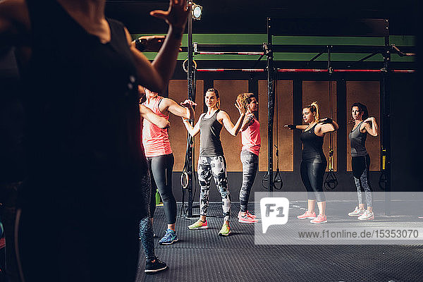 Frauen trainieren im Fitnessstudio  mit erhobenen Armen