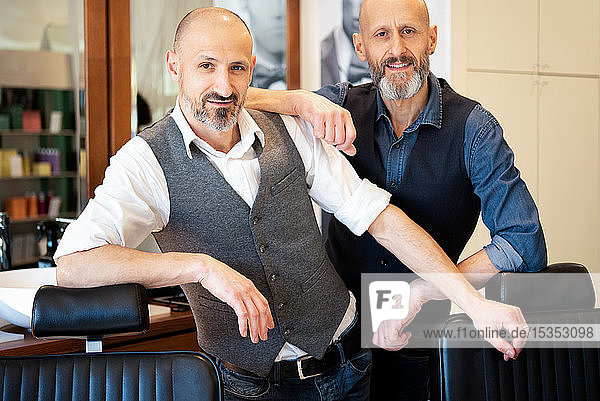 Happy business partners in barber shop