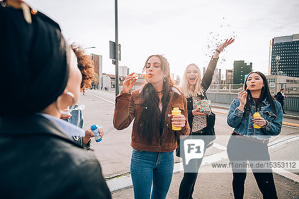 Freunde feiern mit Konfetti und Seifenblasen auf der Straße  Mailand  Italien