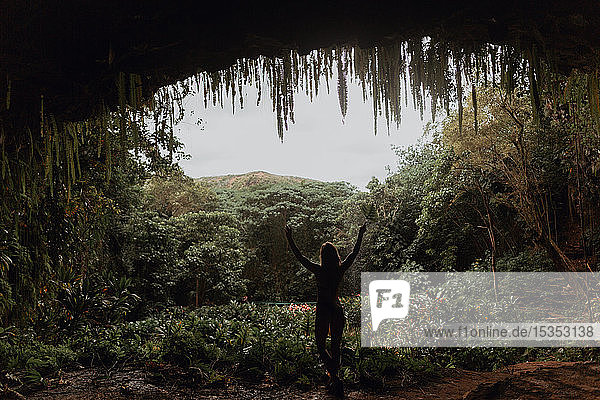 Frau unter einem Höhleneingang im Regenwald  Princeville  Hawaii  USA