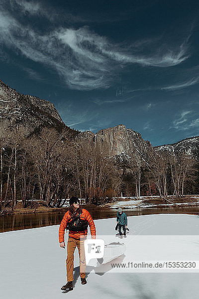 Freunde schleppen Kajak über den Schnee  Yosemite Village  Kalifornien  Vereinigte Staaten