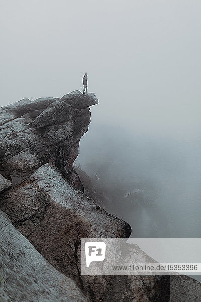 Wanderer genießt Aussicht auf nebeldurchzogenes Tal  Yosemite National Park  Kalifornien  Vereinigte Staaten