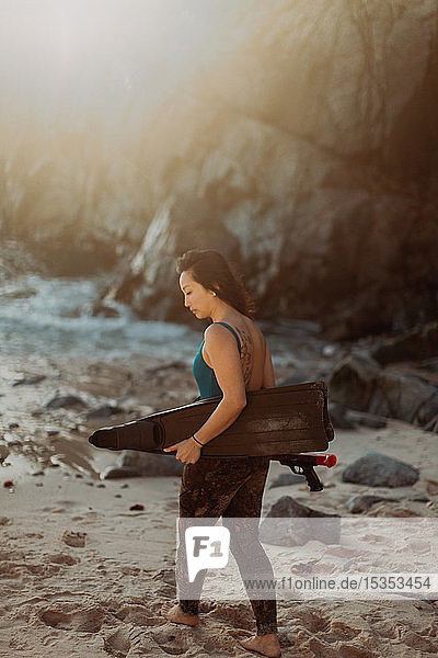 Frau mit Schwimmflossen und Harpune am Strand  Big Sur  Kalifornien  Vereinigte Staaten