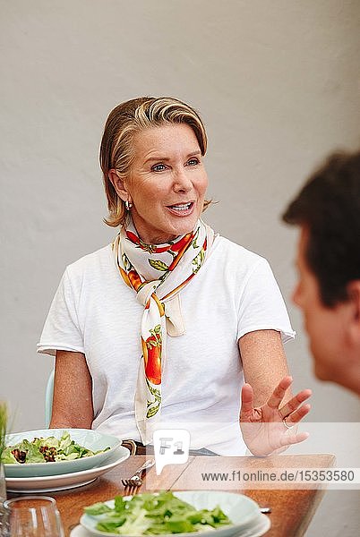 Frau beim Mittagessen mit einem Freund im Restaurant