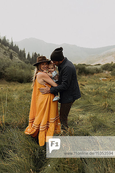 Schwangeres Paar mittlerer Erwachsener umarmt Kleinkind-Tochter in ländlichem Tal  Porträt  Mineral King  Kalifornien  USA